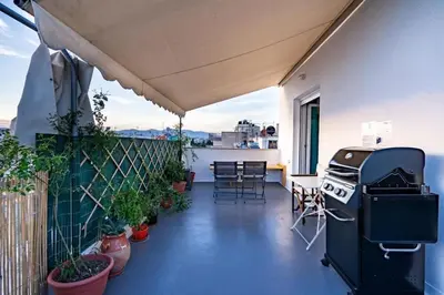 a balcony with a grill and a table and chairs at Acropolis Skyline Sunset, 2 person loft Exarchia in Athens