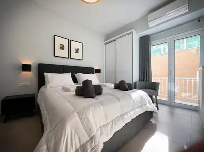 a bedroom with a large white bed and a window at Elegant VIP Apartment - Athens Town in Athens