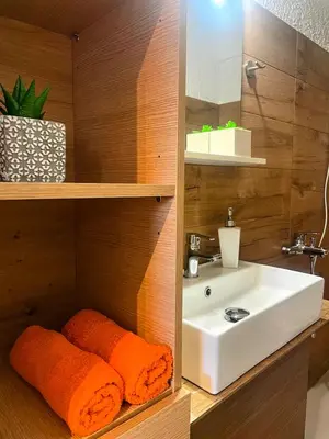 a bathroom with a sink and orange towels at lemonsky apartment in Palaiá Fókaia