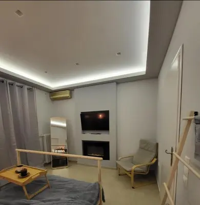 a living room with a tv and a couch and a table at Glory Apartment 3is septemvriou in Athens