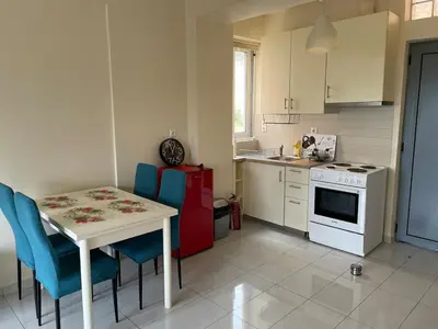 a kitchen with a white table and blue chairs at Argithea View in Papangeláki