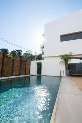 a swimming pool in front of a white building at Amuse Athens Villa in Vari