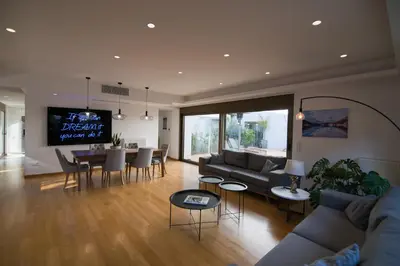 a living room with a couch and a table and chairs at Amuse Athens Villa in Vari