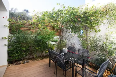 a patio with a table and chairs in a garden at Amuse Athens Villa in Vari