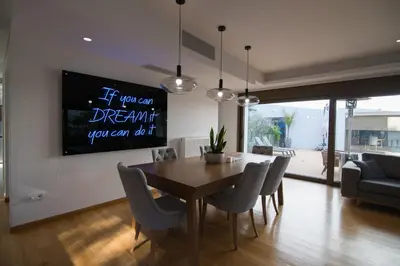 a dining room with a table and chairs and a tv at Amuse Athens Villa in Vari