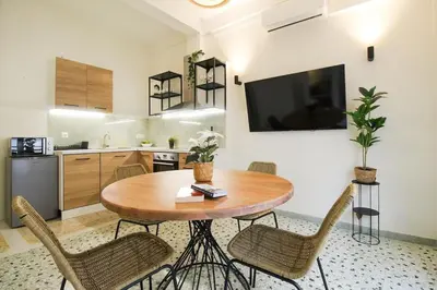 a kitchen and dining room with a wooden table and chairs at Stylish and cosy apartment near the Acropolis in Athens