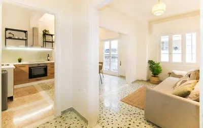 a living room with a couch and a kitchen at Stylish and cosy apartment near the Acropolis in Athens