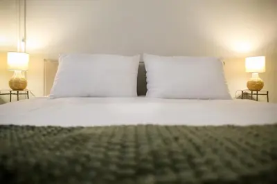a white bed with two pillows and two lamps at Stylish and cosy apartment near the Acropolis in Athens