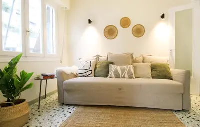a living room with a couch with pillows on it at Stylish and cosy apartment near the Acropolis in Athens