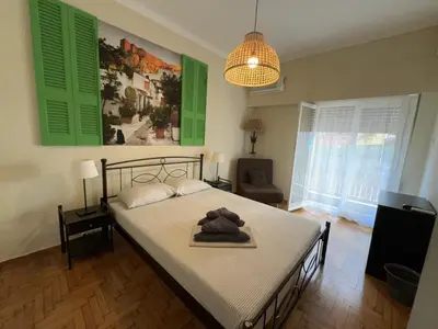 a bedroom with a bed with green shutters at Petaluda House 6 in Athens