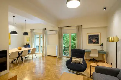 a living room with a table and chairs and a dining room at Plaka Premier Stay - Steps from Acropolis Museum and Metro in Athens