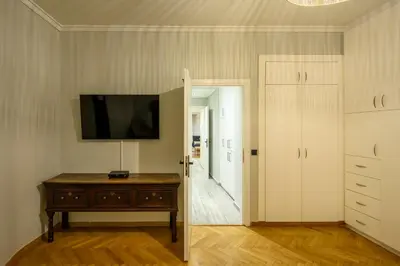a room with a tv on a wall and a wooden table at Plaka Premier Stay - Steps from Acropolis Museum and Metro in Athens