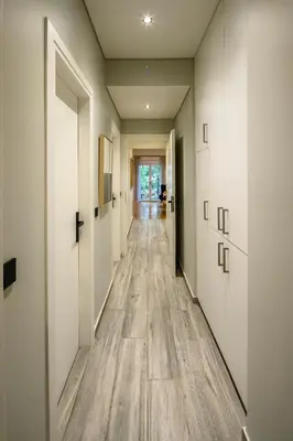 a hallway with white walls and wooden floors at Plaka Premier Stay - Steps from Acropolis Museum and Metro in Athens