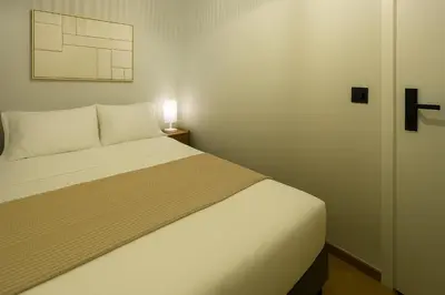 a bedroom with a white bed and a lamp at Plaka Premier Stay - Steps from Acropolis Museum and Metro in Athens