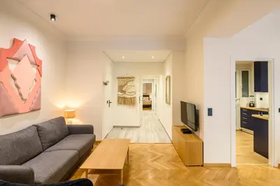 a living room with a couch and a tv at Plaka Premier Stay - Steps from Acropolis Museum and Metro in Athens
