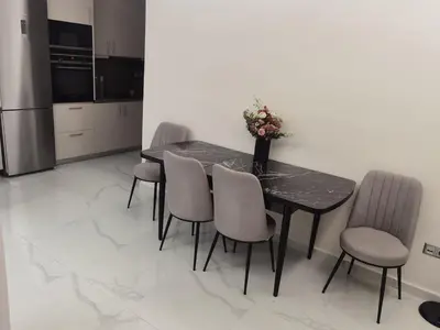 a dining room table with chairs and a vase with flowers at 70m 2BR bright luxury apt in Athens