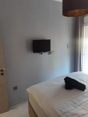 a bedroom with a bed and a flat screen tv on the wall at 70m 2BR bright luxury apt in Athens