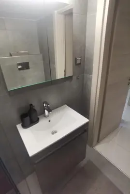 a bathroom with a white sink and a mirror at 70m 2BR bright luxury apt in Athens