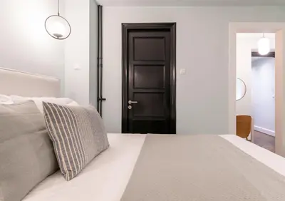 a bedroom with a bed and a black door at Athens Heart Gem Lux Apartment in Athens
