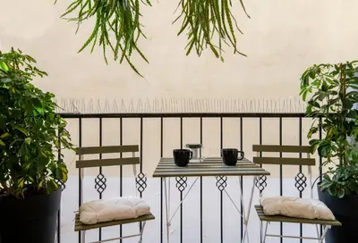 a table and two chairs on a balcony with plants at Athens Heart Gem Lux Apartment in Athens