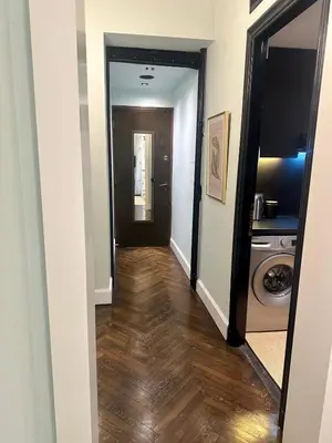 a hallway leading to a laundry room with a washer and dryer at Athens Heart Gem Lux Apartment in Athens