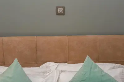 a bed with a brown headboard and a clock on the wall at Kolonaki Prime Location Luxurius Flat in Athens