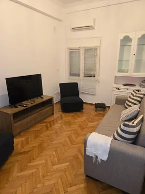 a living room with a couch and a flat screen tv at Piraeus Metro Station in Piraeus