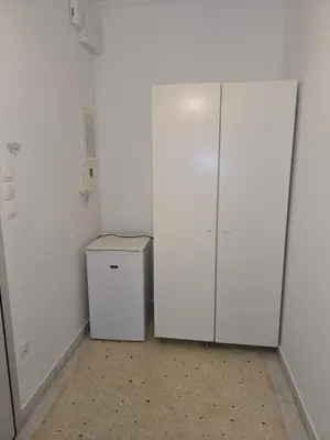 a white room with a refrigerator and a white wall at Piraeus Metro Station in Piraeus