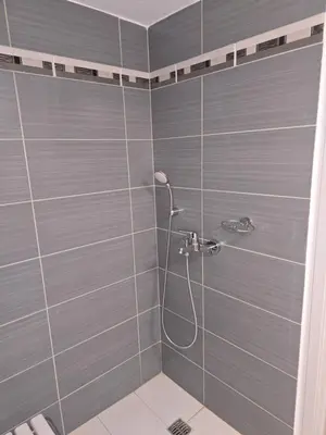 a bathroom with a shower with blue tiles at Piraeus Metro Station in Piraeus