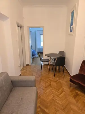 a living room with a couch and a table and chairs at Piraeus Metro Station in Piraeus