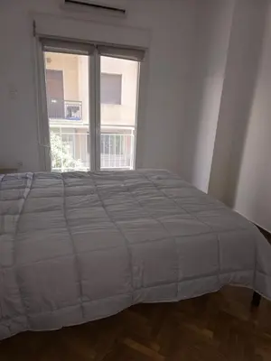 a bed in a room with a large window at Piraeus Metro Station in Piraeus