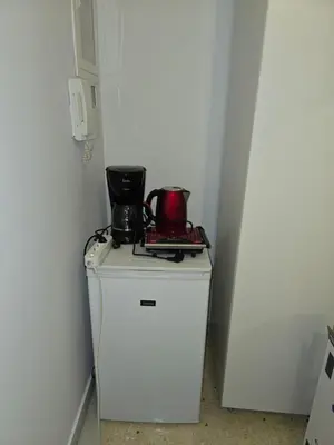 a small white refrigerator with a coffee maker on top of it at Piraeus Metro Station in Piraeus