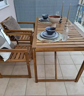 a wooden table with bowls and plates on it at Penthouse in Koukaki with Acropolis view in Athens