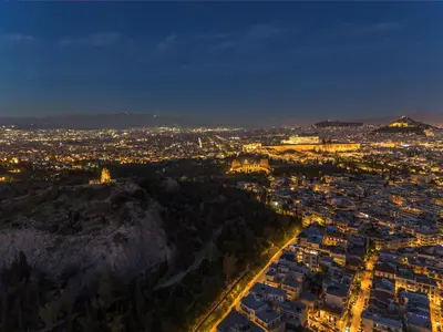 an aerial view of a city at night at Penthouse in Koukaki with Acropolis view in Athens