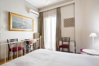 a bedroom with a bed and a table and chairs at Acropolis Metro Station- Great Located Flat 125m2 in Athens