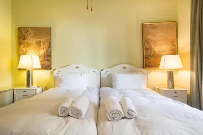 two beds with white towels on them in a bedroom at Acropolis Metro Station- Great Located Flat 125m2 in Athens