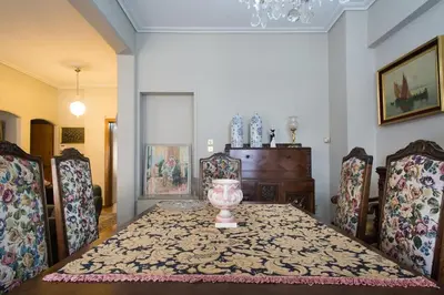a dining room with a table with chairs and a vase at Acropolis Metro Station- Great Located Flat 125m2 in Athens