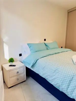 a bedroom with a bed with blue sheets and a night stand at Modern Designer Home & Stylish Comfort Goudi in Athens