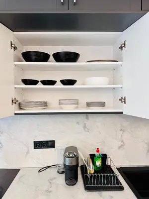 a kitchen with white shelves with bowls and plates at Modern Designer Home & Stylish Comfort Goudi in Athens