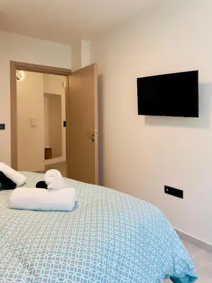 a bedroom with a bed and a flat screen tv at Modern Designer Home & Stylish Comfort Goudi in Athens