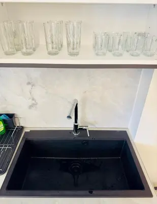 a sink in a kitchen with glasses on a shelf at Modern Designer Home & Stylish Comfort Goudi in Athens