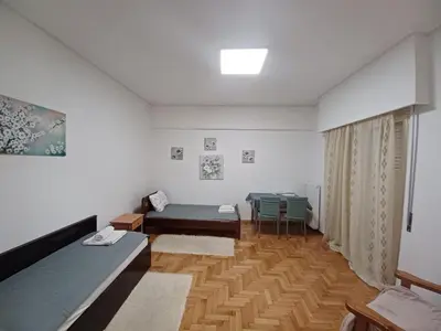 a room with two beds and a table in it at Spacious Apartment 2 minutes from Omonoia Metro in Athens