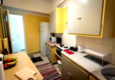 a kitchen with yellow cabinets and a counter top at Spacious Apartment 2 minutes from Omonoia Metro in Athens