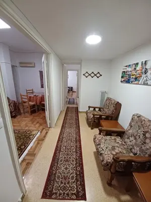 a living room with two chairs and a rug at Spacious Apartment 2 minutes from Omonoia Metro in Athens