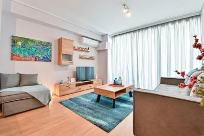 a living room with a couch and a tv at Comfortable Apartment, close to Piraeus Port SPC2 in Piraeus