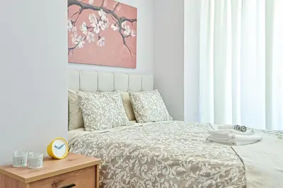 a bedroom with a bed and a table with a clock at Comfortable Apartment, close to Piraeus Port SPC2 in Piraeus