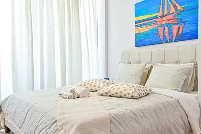 a bedroom with a bed with pillows and a painting at Comfortable Apartment, close to Piraeus Port SPC2 in Piraeus