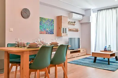 a dining room with a table and green chairs at Comfortable Apartment, close to Piraeus Port SPC2 in Piraeus