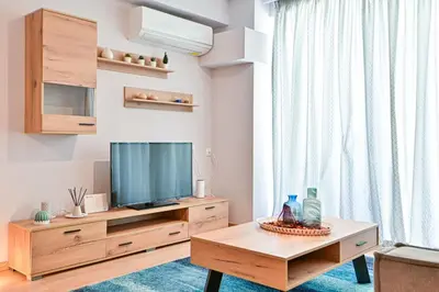 a living room with a television and a table at Comfortable Apartment, close to Piraeus Port SPC2 in Piraeus