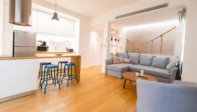 a living room with a couch and chairs and a kitchen at Parkside Kolonaki in Athens